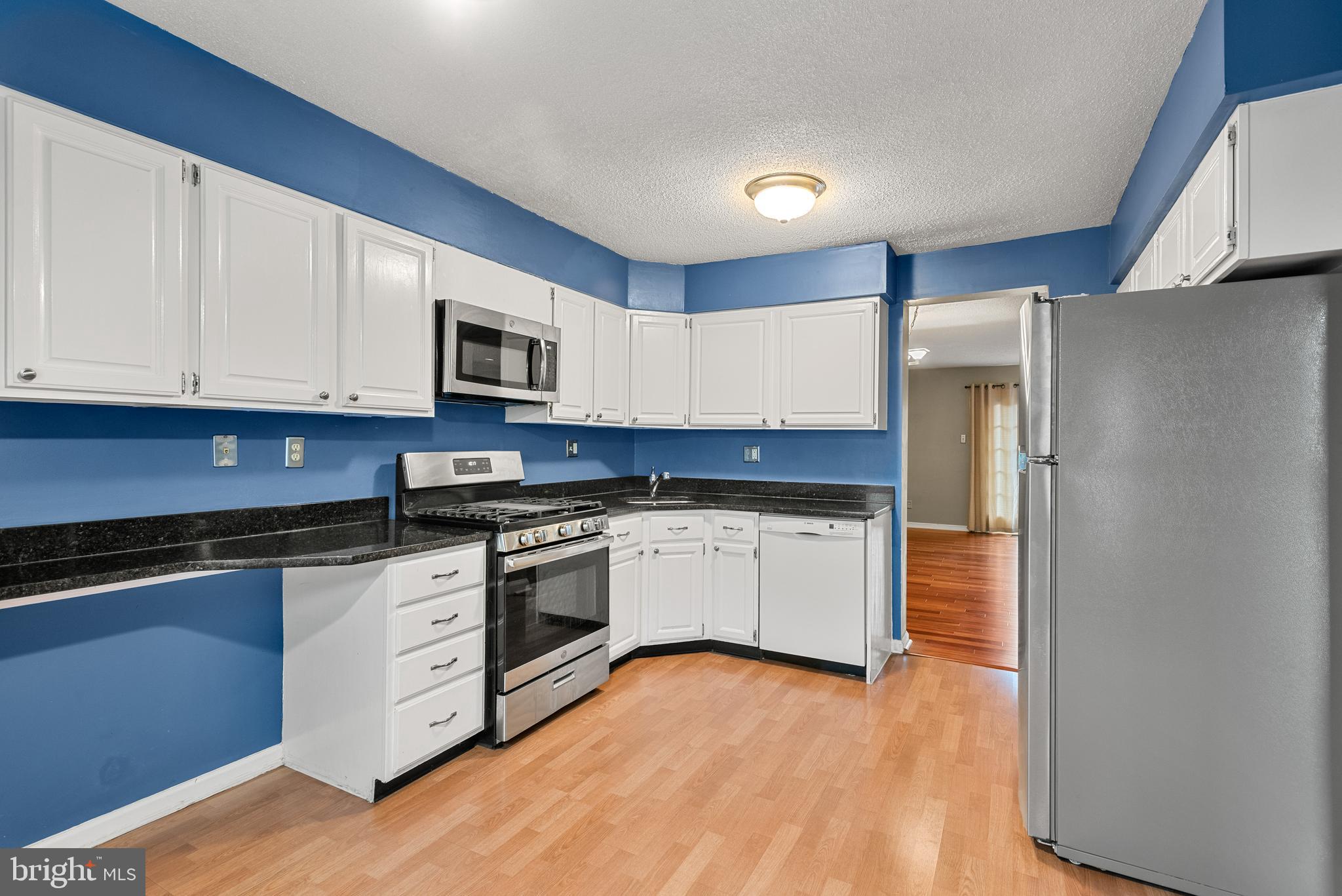 5 Lantern Lane Chesterbrook, PA 19087 - Photo 11 of 30 a kitchen with granite countertop a refrigerator stove top oven and sink with wooden floor