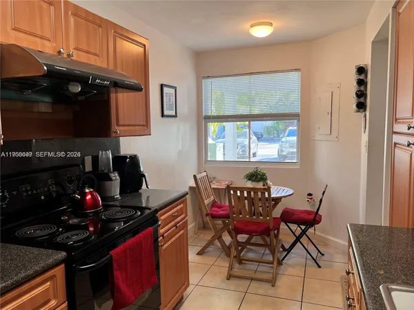 a kitchen with stainless steel appliances a stove a sink and chairs