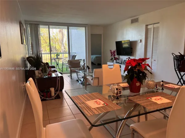 a living room with furniture a flat screen tv and a floor to ceiling window