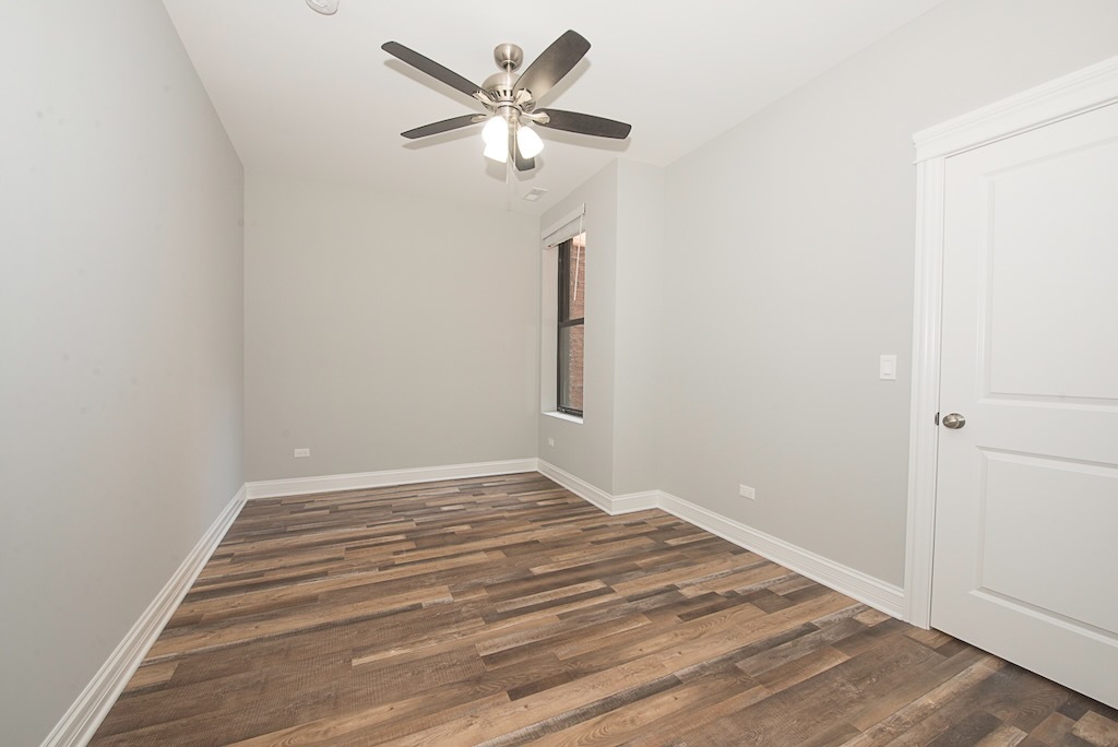 4117 South Michigan Avenue, Unit 2N Chicago, IL 60653 - Photo 12 of 20 a view of a room with wooden floor and a ceiling fan