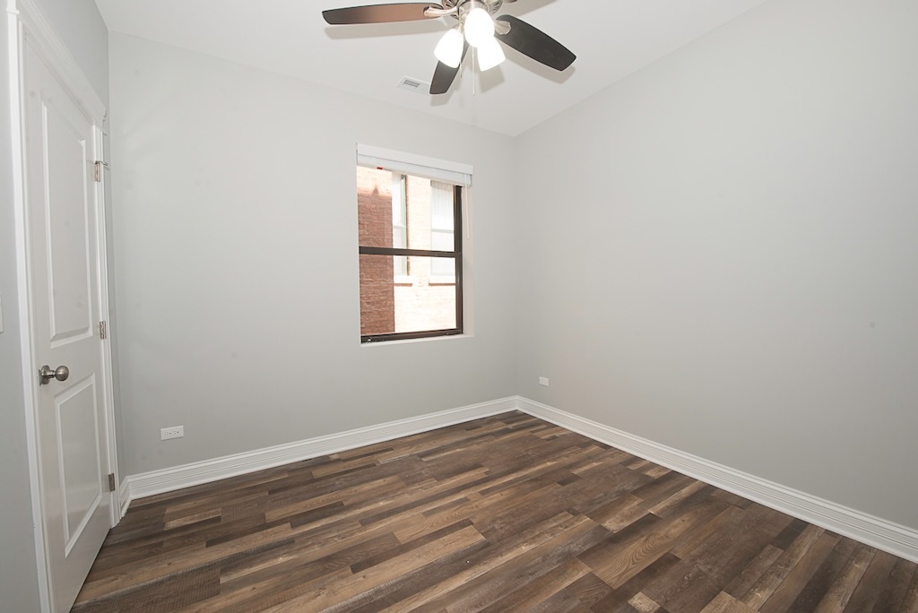 4117 South Michigan Avenue, Unit 2N Chicago, IL 60653 - Photo 13 of 20 an empty room with wooden floor fan and windows