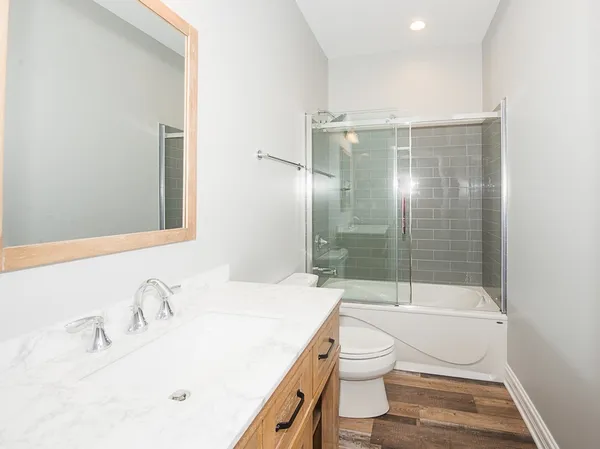 a bathroom with a sink a toilet and shower