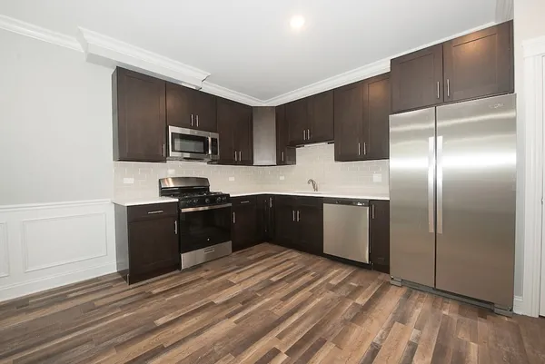a kitchen with granite countertop a refrigerator and a stove top oven