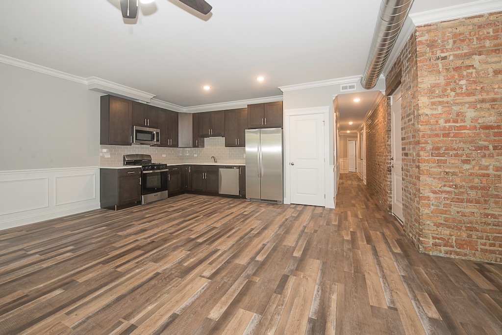 4117 South Michigan Avenue, Unit 2N Chicago, IL 60653 - Photo 6 of 20 a large kitchen with a wooden floor and stainless steel appliances