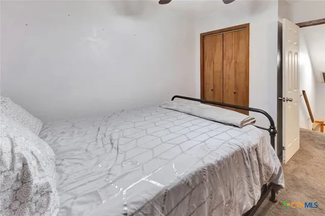 a bedroom with a bed and a refrigerator