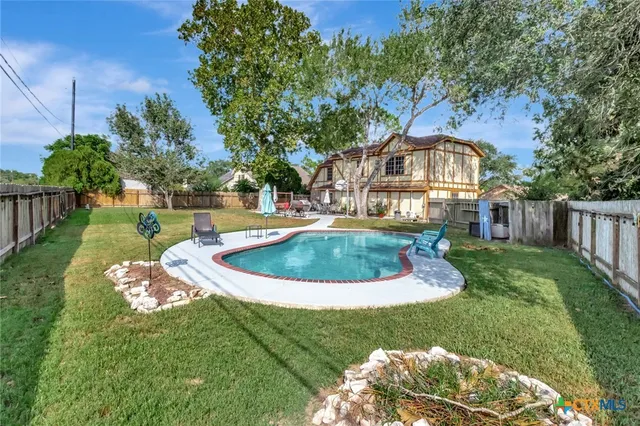 a view of a house with a big yard potted plants and a large tree