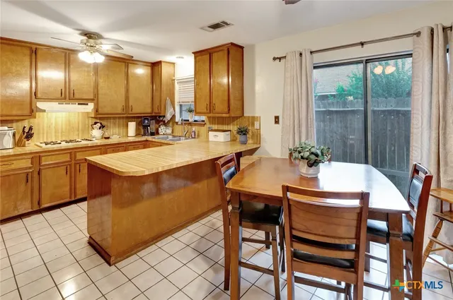 a kitchen with a sink and chairs