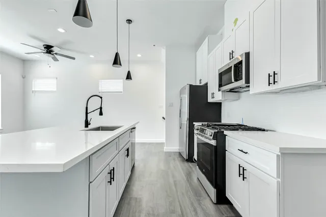 a kitchen with white cabinets stainless steel appliances and sink