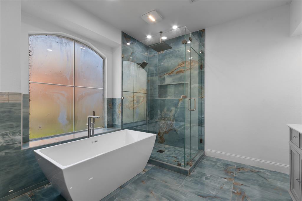 225 Freedom Court Rockwall, TX 75032 - Photo 17 of 28 a bathroom with a bathtub and a shower