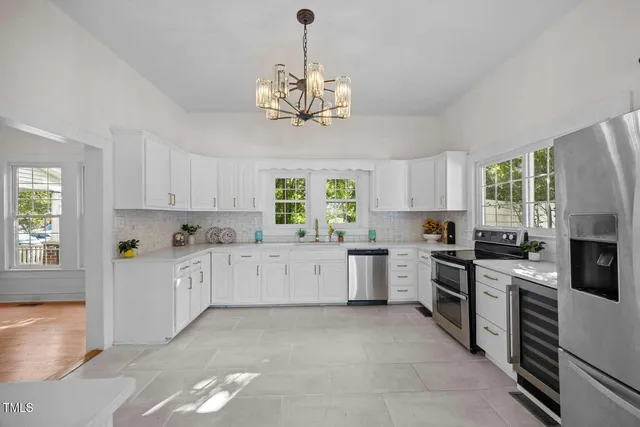 a large kitchen with a stove top oven a sink a window and dining table