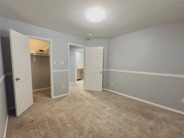an empty room with closet and windows