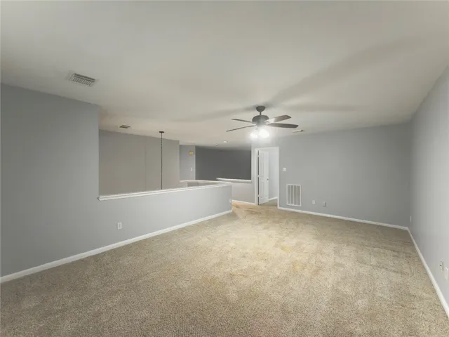 a view of an empty room with a ceiling fan