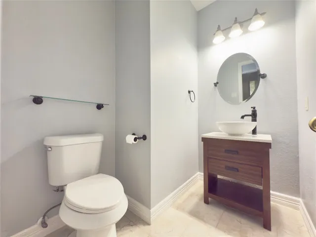 a bathroom with a toilet a sink and mirror