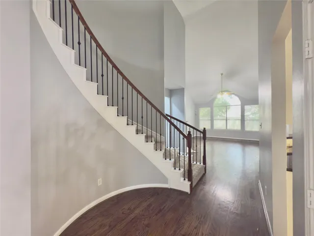 a view of staircase with wooden floor and white walls