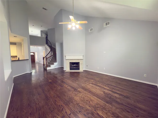 a view of a livingroom with wooden floor and a ceiling fan