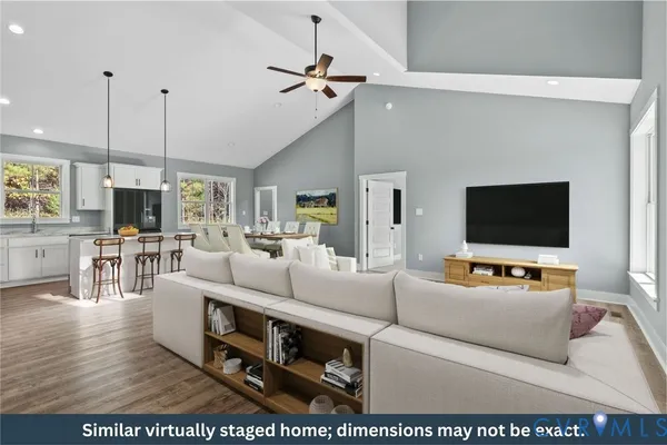 a kitchen with stainless steel appliances granite countertop a stove a sink a refrigerator a microwave and white cabinets