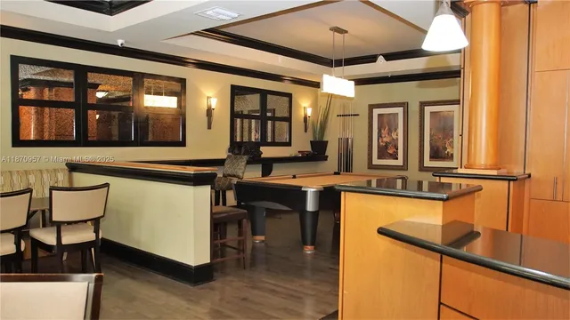 a kitchen with stainless steel appliances granite countertop a table chairs in it and wooden floors