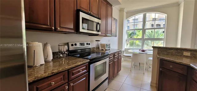 a kitchen with stainless steel appliances granite countertop a stove a sink and a microwave