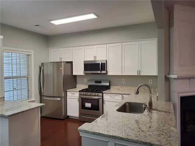 a kitchen with stainless steel appliances granite countertop a refrigerator sink and stove