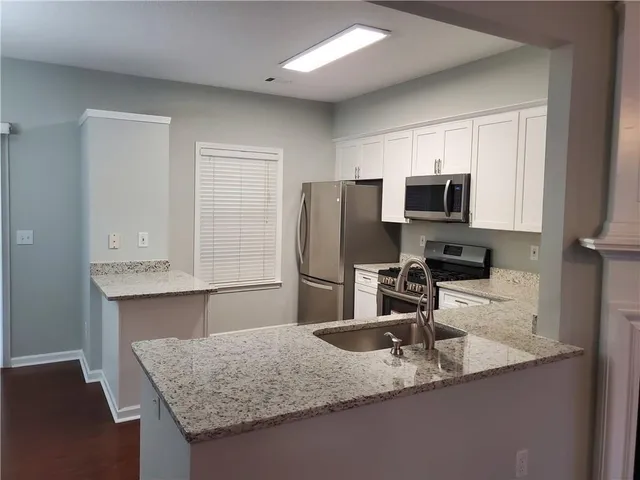 a kitchen with stainless steel appliances granite countertop a sink refrigerator and microwave