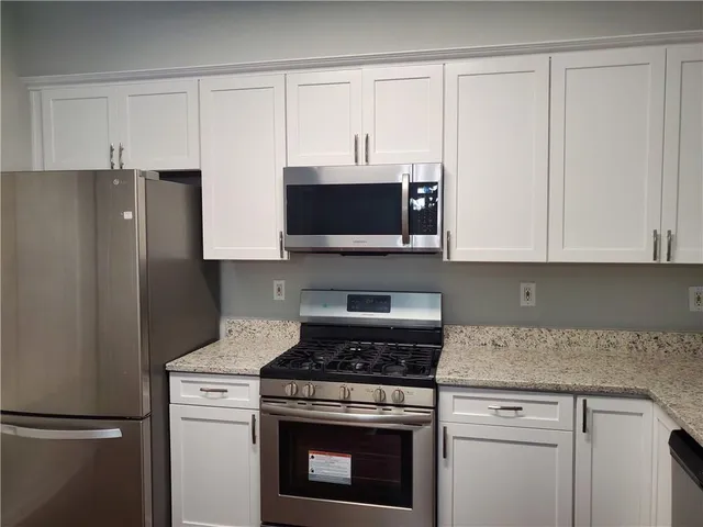 a kitchen with stainless steel appliances white cabinets and a stove