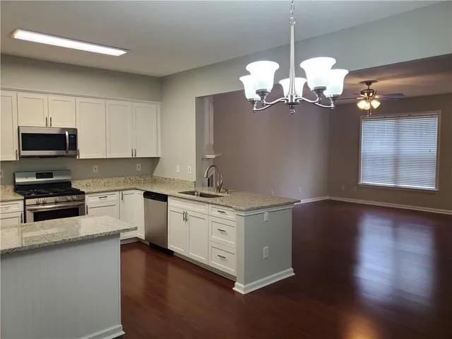 a kitchen with stainless steel appliances granite countertop a stove a sink and a microwave