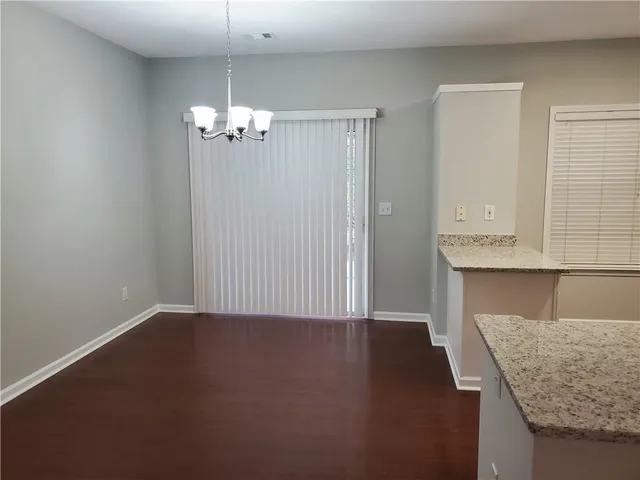 an empty room with a kitchen island wooden floor and a ceiling fan