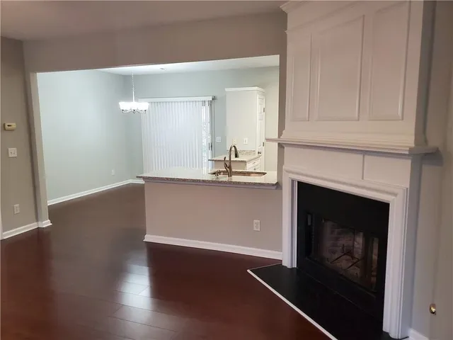 a view of a livingroom with wooden floor and a fireplace