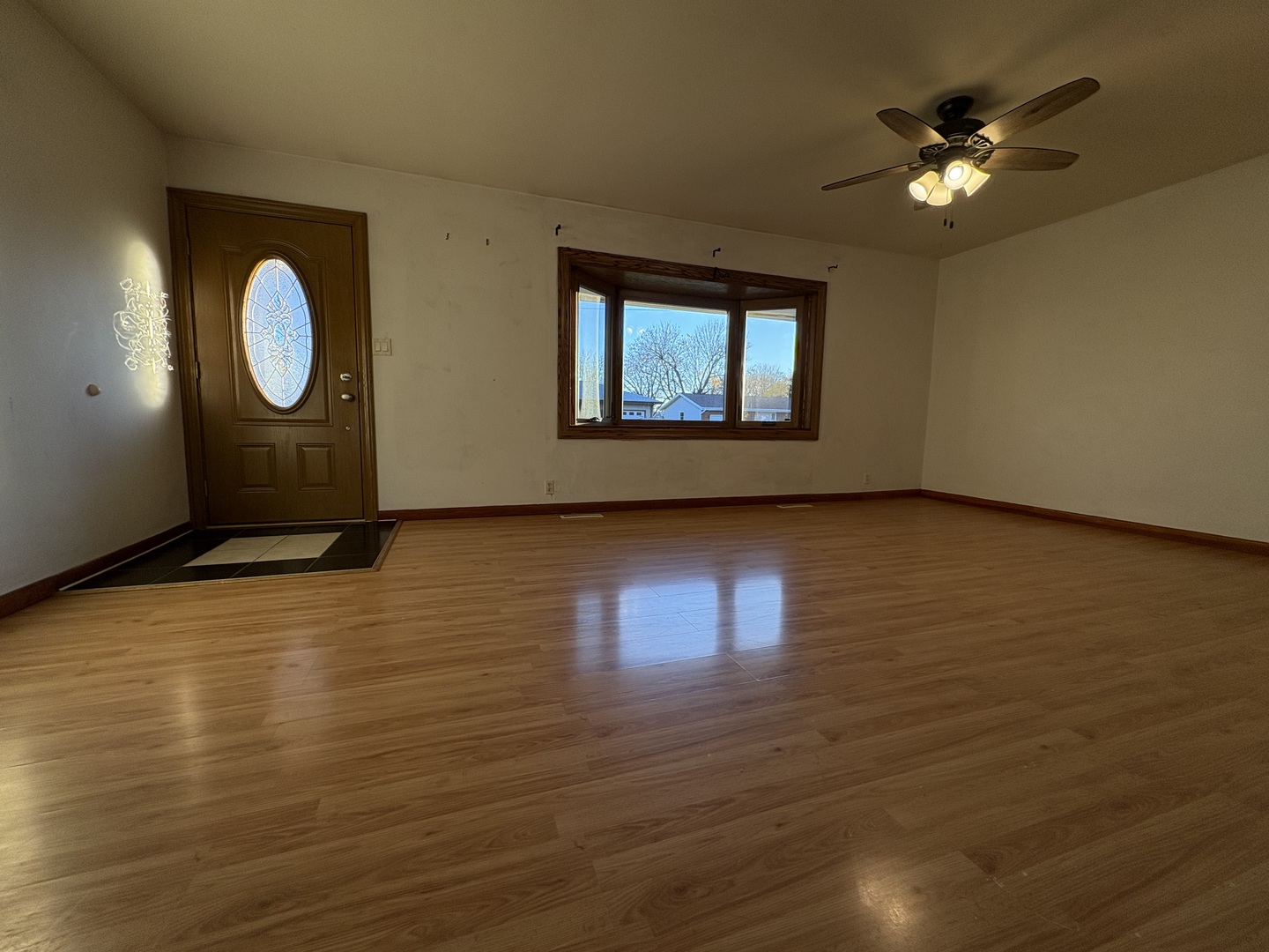 411 Phyllis Avenue Rochelle, IL 61068 - Photo 3 of 26 a view of an empty room with wooden floor and a window
