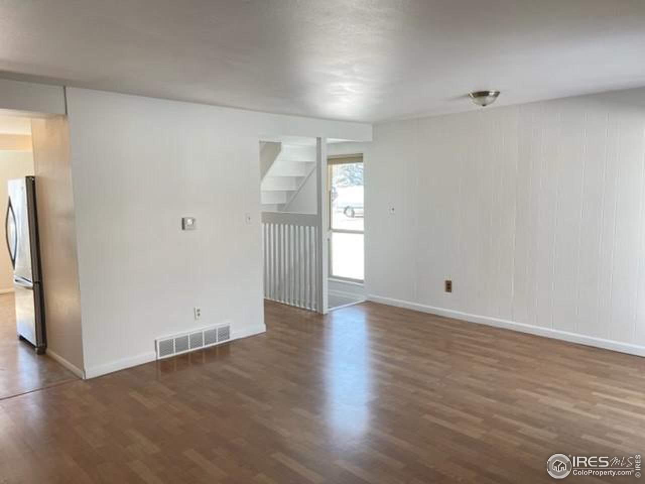 1187 Bear Mountain Drive, Unit A Boulder, CO 80305 - Photo 14 of 26 a view of an empty room with wooden floor and a window