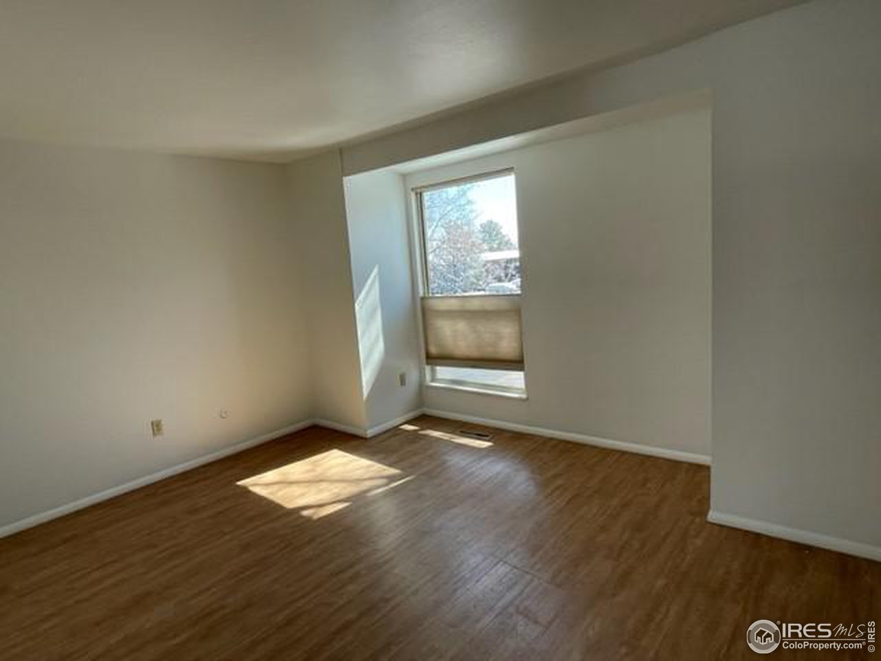 1187 Bear Mountain Drive, Unit A Boulder, CO 80305 - Photo 21 of 26 an empty room with wooden floor and windows