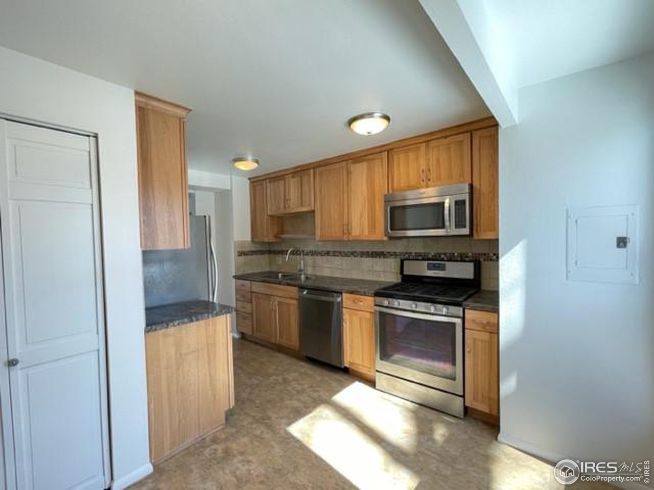 1187 Bear Mountain Drive, Unit A Boulder, CO 80305 - Photo 7 of 26 a kitchen with granite countertop a refrigerator and a stove top oven