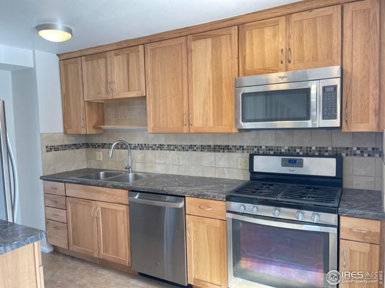 1187 Bear Mountain Drive, Unit A Boulder, CO 80305 - Photo 8 of 26 a kitchen with granite countertop a stove sink and cabinets