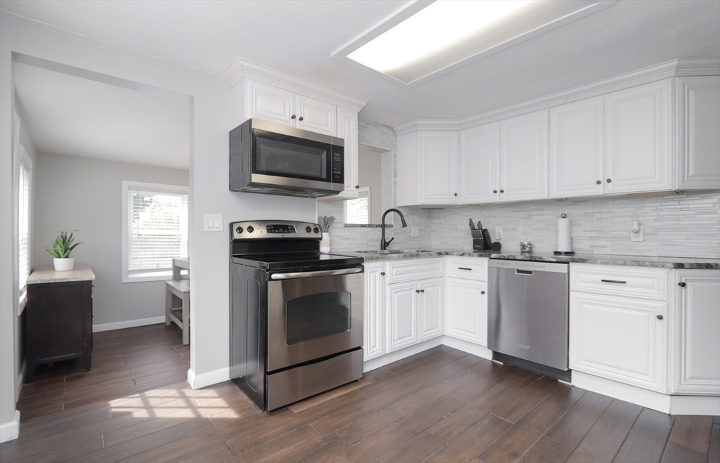 114 Davis Street Springfield, MA 01104 - Photo 5 of 42 a kitchen with granite countertop a sink a stove top oven and cabinetry