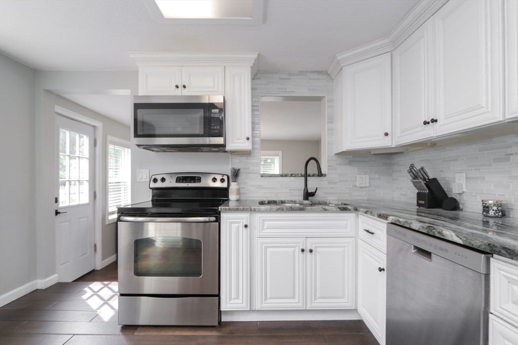 114 Davis Street Springfield, MA 01104 - Photo 6 of 42 a kitchen with granite countertop a stove sink and cabinets