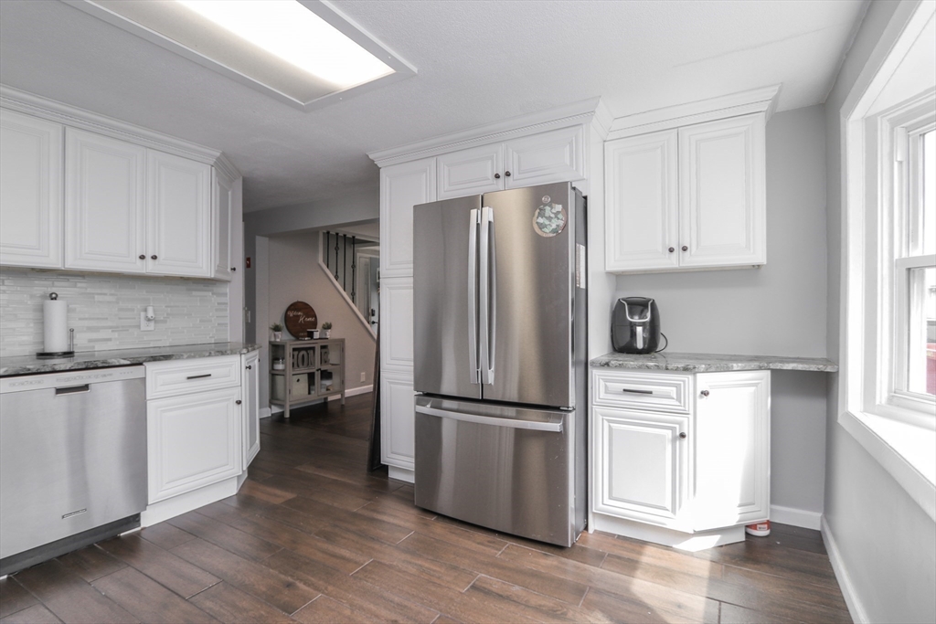 114 Davis Street Springfield, MA 01104 - Photo 8 of 42 a kitchen with a refrigerator stove and wooden cabinets