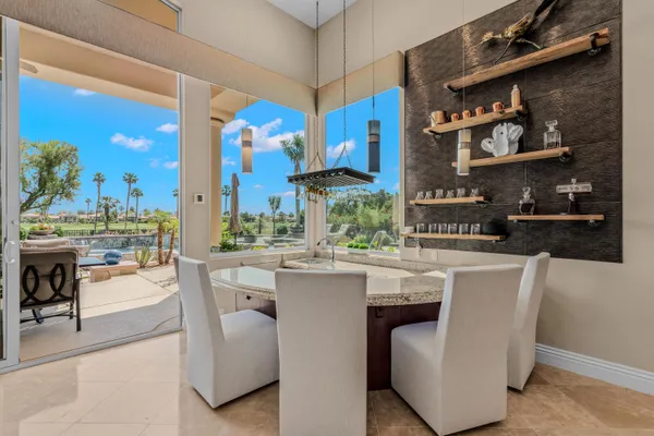 a view of a dining room and livingroom with furniture wooden floor a chandelier