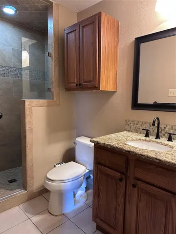 an empty room that has a chandelier fan and windows