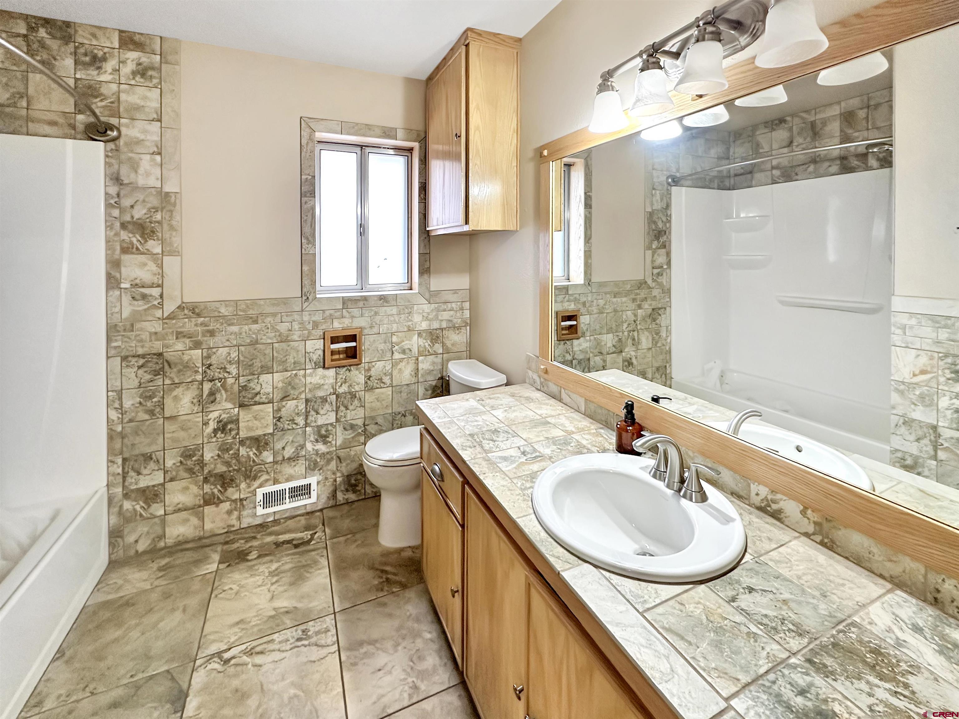 6644 County Road 203 Durango, CO 81301 - Photo 14 of 21 a bathroom with a granite countertop sink a mirror and a shower