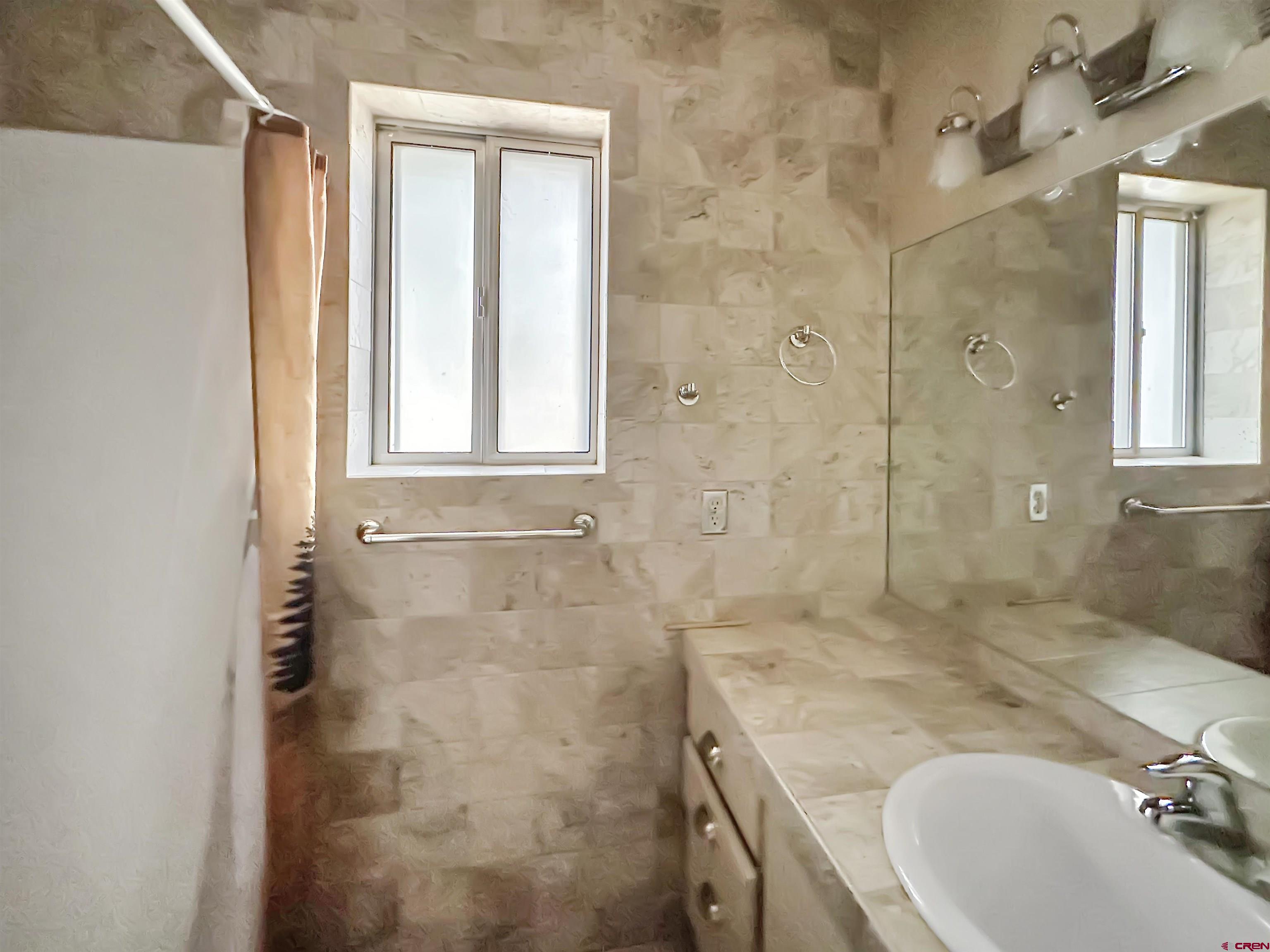 6644 County Road 203 Durango, CO 81301 - Photo 20 of 21 a bathroom with a granite countertop sink a mirror and a shower