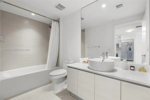 a bathroom with a double vanity sink toilet mirror and shower