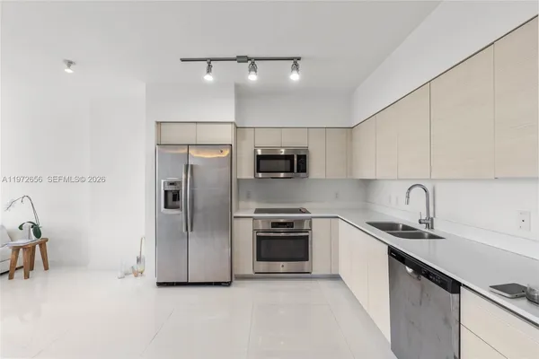 a kitchen with stainless steel appliances a sink stove and refrigerator