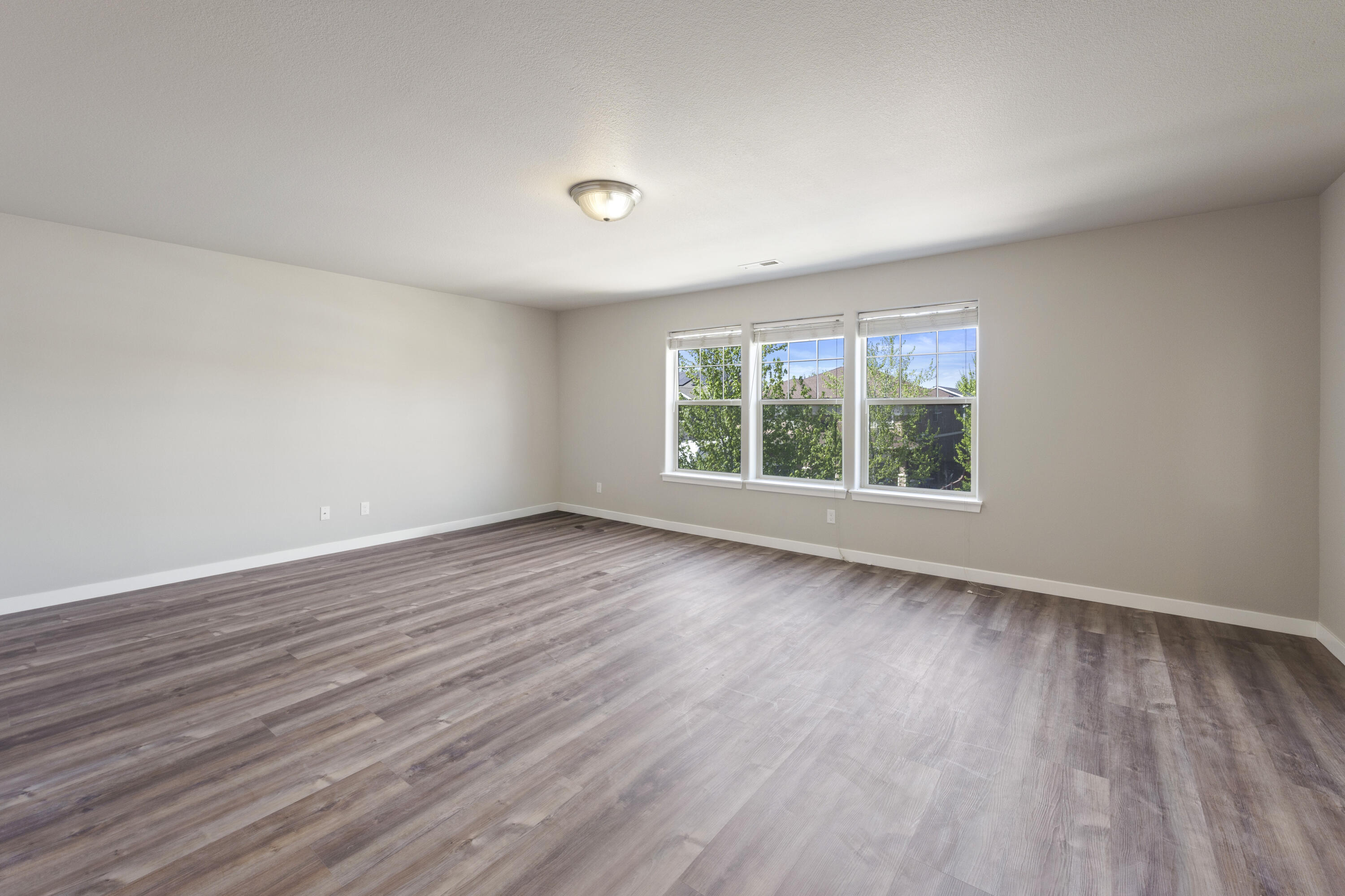 21189 Ritz Place Bend, OR 97702 - Photo 17 of 37 an empty room with wooden floor and windows