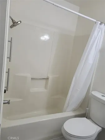 a white toilet sitting next to a bath tub