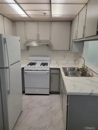 a kitchen with a sink stove and refrigerator