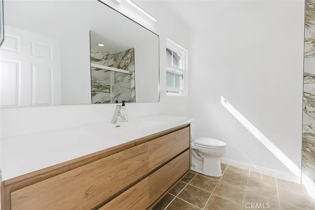 a bathroom with a sink a toilet and a mirror