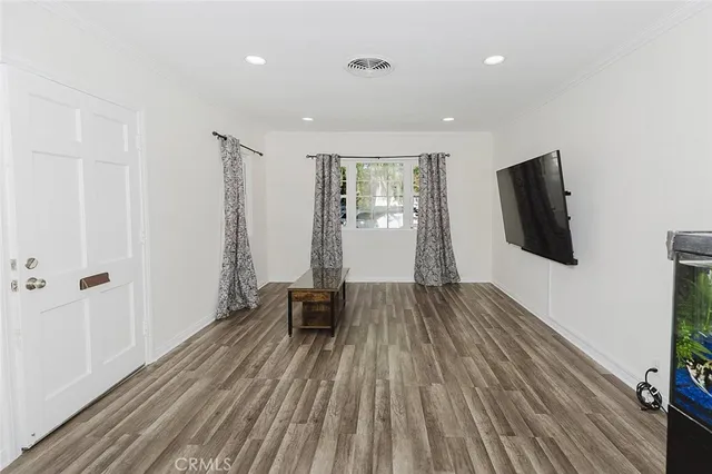 a view of a livingroom with wooden floor and staircase