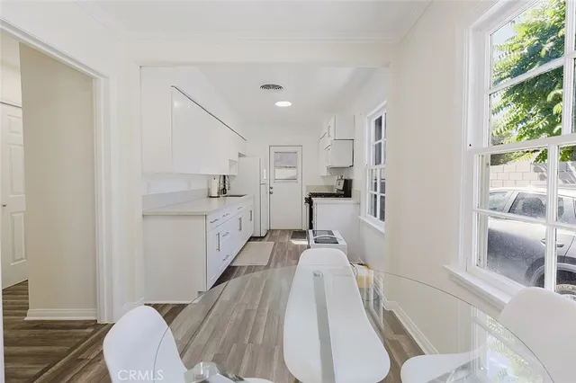a view of a kitchen with furniture and wooden floor
