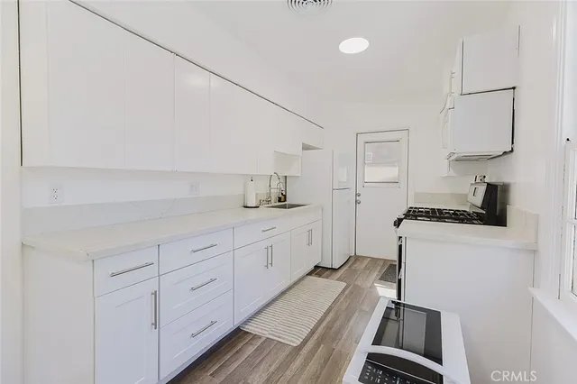 a kitchen with white cabinets and appliances