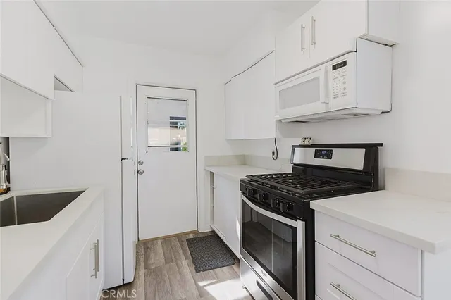 a kitchen with white cabinets and appliances